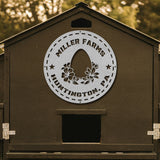 Brown wooden coop with 'Miller Farms Huntington, PA' logo on a blurred natural background