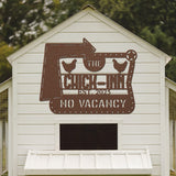 White chicken coop with a decorative sign reading 'The Chick Inn No Vacancy' on a blurred natural background.