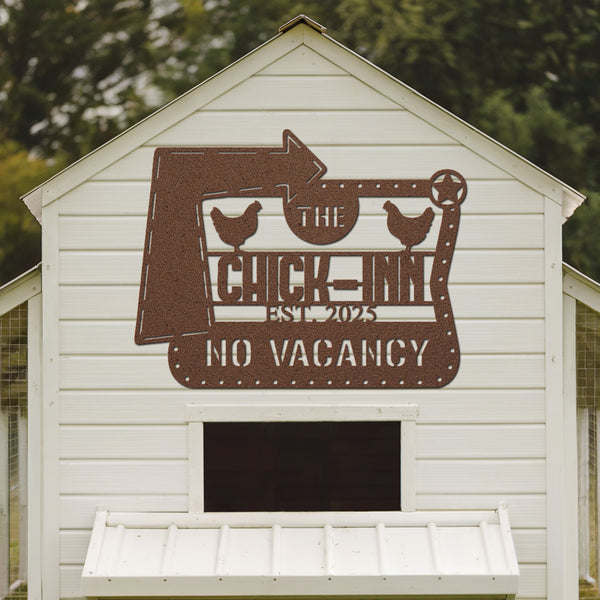 White chicken coop with a decorative sign reading 'The Chick Inn No Vacancy' on a blurred natural background.