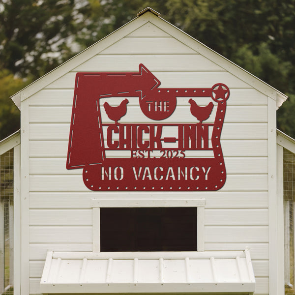 White chicken coop with a red sign reading 'The Chick Inn No Vacancy' on a blurred green background.