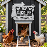 A decorative metal sign reading 'THE CHICK-INN EST. 2025 NO VACANCY' mounted on a small black chicken coop with galvanized trim.