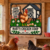 A decorative metal sign for a chicken coop hangs on a wooden coop door. The sign features a cartoon chicken, eggs, flowers, a small coop, and the text 'COOL CHICKS LIVE HERE' and 'MARY'S CHICKEN COOP EST.