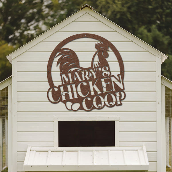 White chicken coop with a rooster logo and 'Mary's Chicken Coop' text on a wooden background.