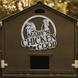 Chicken coop with 'Mary's Chicken Coop' sign on a wooden background