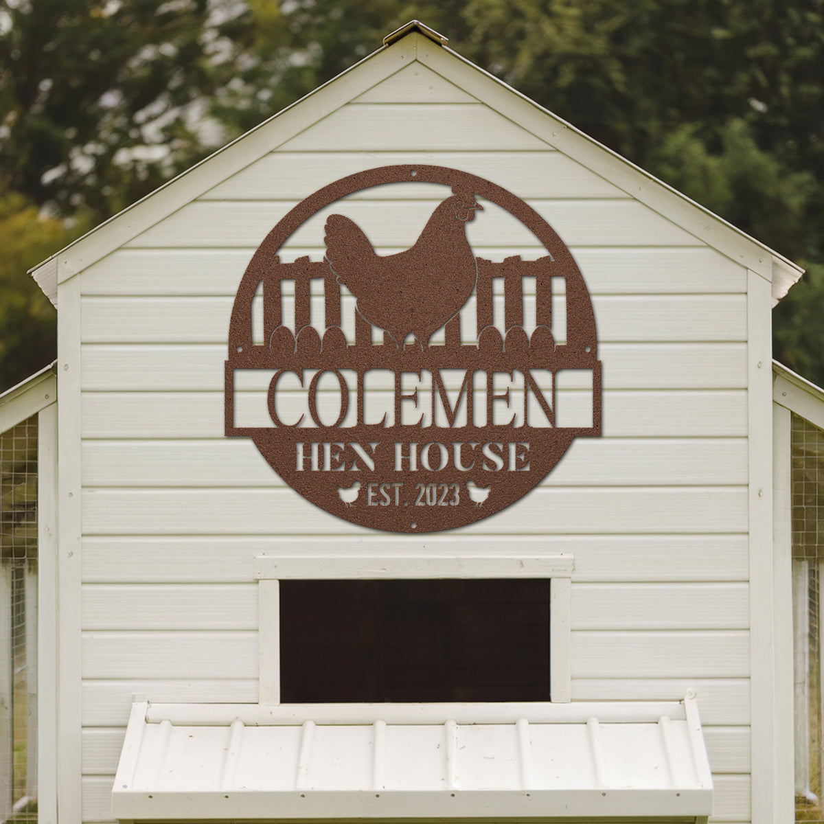 White chicken coop with a brown metal sign featuring the name 'Colemen Hen House' and establishment year.