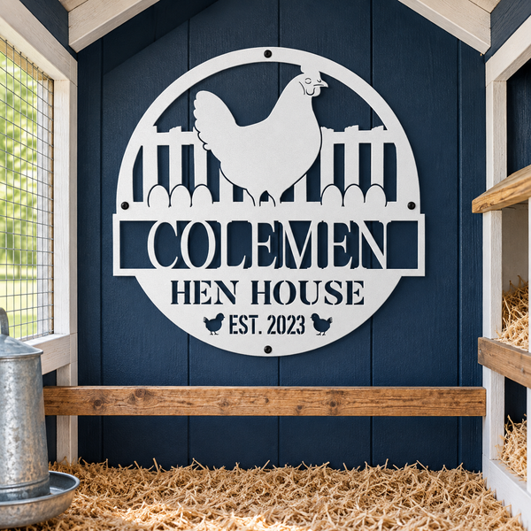 A white metal sign reading “COLEМЕН HEN HOUSE EST. 2023” with a chicken silhouette and fence cutout, mounted on a dark blue wooden chicken coop wall above a wooden perch.
