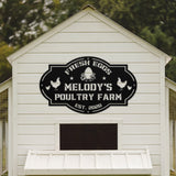 White barn with 'Melody's Poultry Farm' sign on a blurred green background