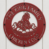 A round red metal wall sign featuring a cutout hen and chicks with the text 'THE KING FAMILY CHICKEN COOP' and 'EST 2025', mounted on a white wood plank wall.