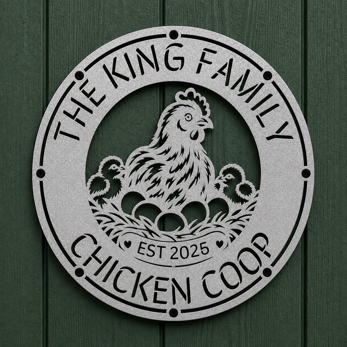 A round metal garden sign featuring a chicken and two chicks with eggs in a nest, surrounded by the text 'THE KING FAMILY CHICKEN COOP' and 'EST 2025'. The sign is mounted on a dark green wood-paneled wall.