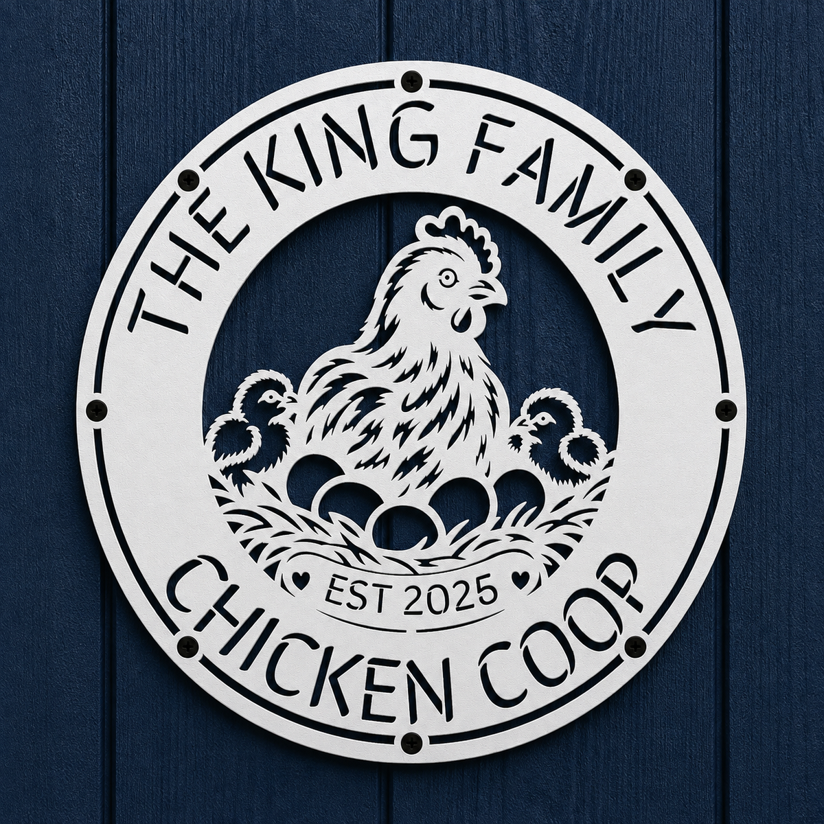A round white metal sign featuring a cutout illustration of a hen, two chicks, and eggs, with the text 'THE KING FAMILY CHICKEN COOP' and 'EST 2025', mounted on a dark blue wood plank background.