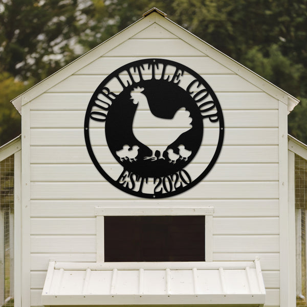 White chicken coop with a black circular design featuring a rooster and chickens on the side.