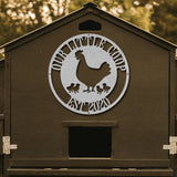 Brown chicken coop with a metal logo featuring a rooster and chickens, set against a blurred natural background.