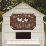 White chicken coop with a brown sign featuring text and illustrations of chickens.