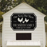 White chicken coop with a black sign featuring text and chicken illustrations.
