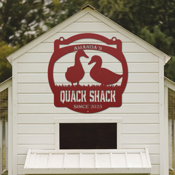White shed with a red 'Quack Shack' sign featuring ducks on the side.