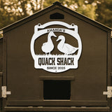 Decorative sign on a duck house with 'Amanda's Quack Shack' text and duck illustrations.