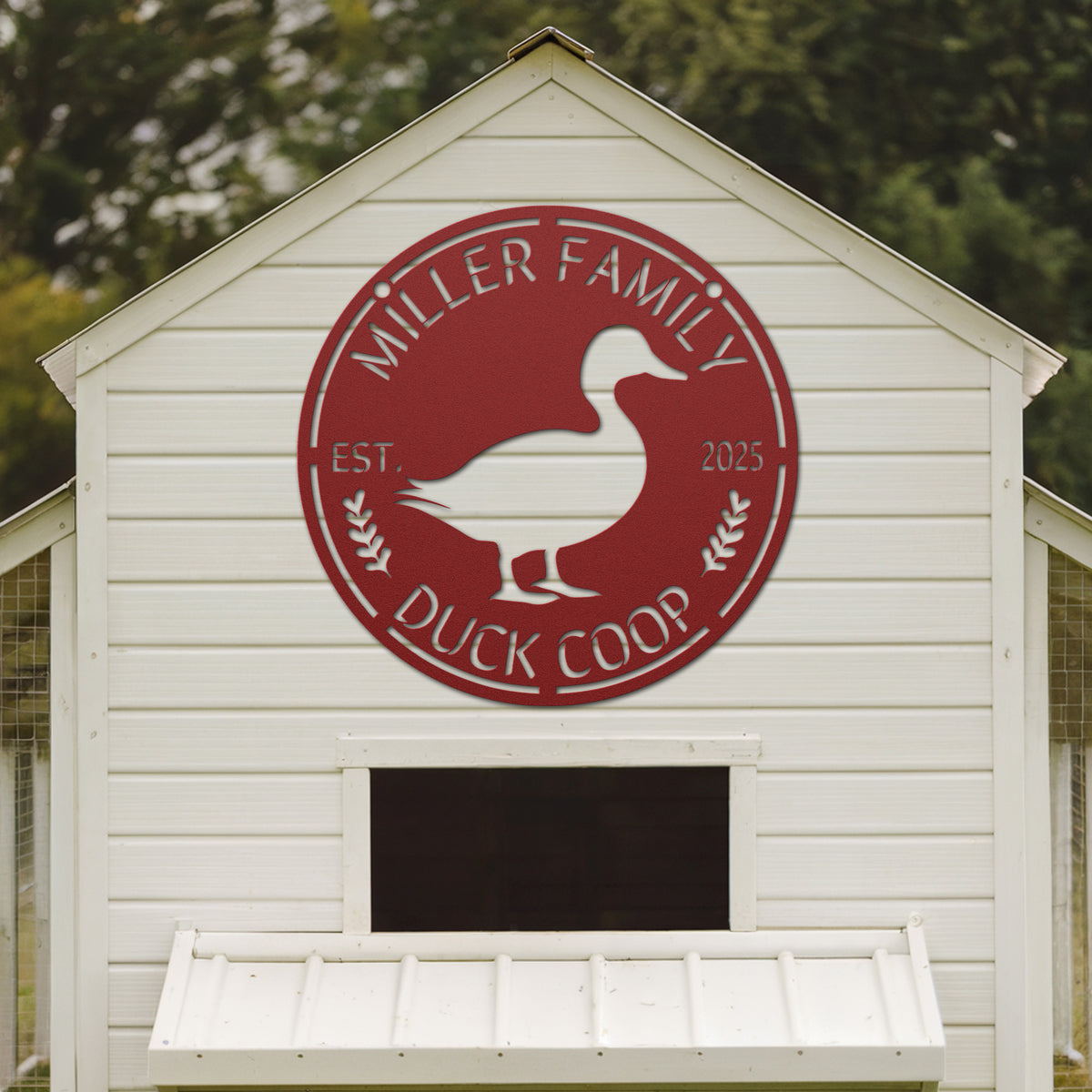 White duck coop with a red 'Miller Family Duck Coop' logo on a blurred green background