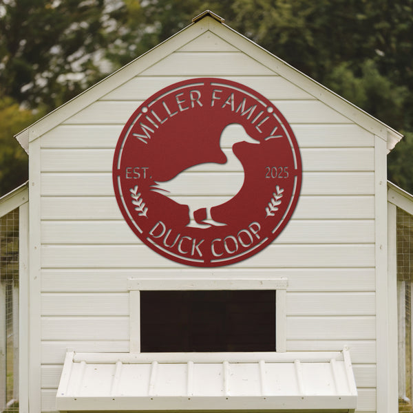 White duck coop with a red 'Miller Family Duck Coop' logo on a blurred green background